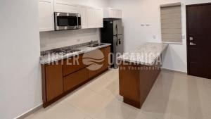 a kitchen with a refrigerator and a microwave at Alberca con la mejor vista a la Marina Mazatlán in Mazatlán