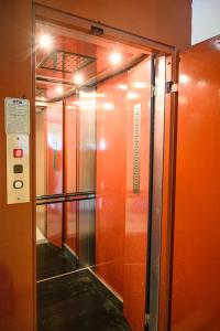 an elevator in a building with orange walls and lights at Sunrise2 in Paralia Katerinis