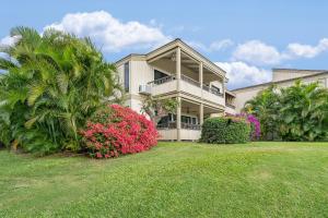 a large house with flowering plants in front of it at Wailea Ekolu 102 - Molokini Views, Split AC in Wailea