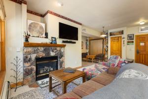a living room with a couch and a fireplace at 5949 Hidden River Lodge Condo in Keystone