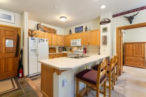 a kitchen with wooden cabinets and a white refrigerator at 5949 Hidden River Lodge Condo in Keystone