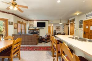 a kitchen and living room with a table and chairs at 5949 Hidden River Lodge Condo in Keystone