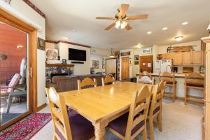 a dining room and kitchen with a wooden table and chairs at 5949 Hidden River Lodge Condo in Keystone +13 photos