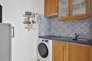 eine Küche mit einer Waschmaschine und einem Waschbecken in der Unterkunft Charming T2 in 2nd arrond of Paris - Welkeys in Paris