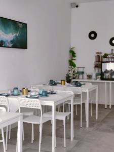 un comedor blanco con mesas blancas y sillas blancas en Villa Paraíso da Caparica en Charneca