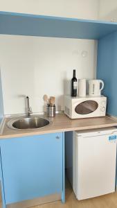 a kitchen with a sink and a microwave at Villa Paraíso da Caparica in Charneca
