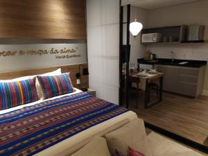 a bedroom with a bed and a table and a kitchen at Wanderlust Experience Hotel Best Western in Campos do Jordão +21 photos