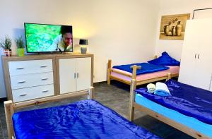Zimmer mit 2 Etagenbetten und einem TV in der Unterkunft Gästehaus Don Camillo in Ensdorf