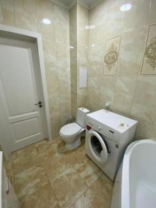 阿克托比的住宿－Уютная кв в ЖК Нектар мкр Батыс-2，一间带卫生间和洗衣机的浴室