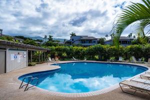 a large swimming pool with chairs and a house at Wailea Ekolu 407 - Renovated, Split AC, Ocean View in Wailea