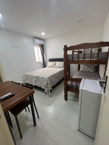 Cette petite chambre comprend des lits superposés et une table. dans l'établissement ECOSURF, à Cabo Frio