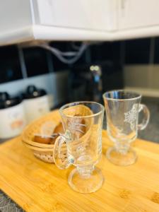 two glasses sitting on top of a cutting board at City Mill - Next to Town Centre Shopping and Restaurants - Free Parking in Burton upon Trent
