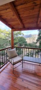 eine Veranda mit einer Bank und einem Tisch auf dem Balkon in der Unterkunft Terrambú in Cordoba