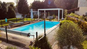 a swimming pool with a fence around it at Chambres d'hôtes Les Vernayes in Amplepuis