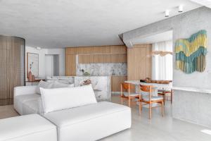 een woonkamer met een witte bank en een tafel bij Luxuoso apartamento com a melhor vista de BC in Balneário Camboriú