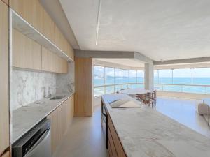 een keuken met een aanrecht en uitzicht op de oceaan bij Luxuoso apartamento com a melhor vista de BC in Balneário Camboriú