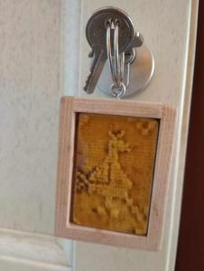 ein Bild in einem Holzrahmen mit einem Schlüssel in der Unterkunft BB Le Violette in Tortolì