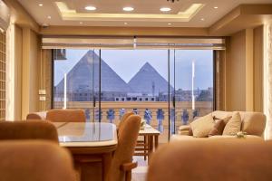 un soggiorno con vista sulle piramidi di Pyramids Charm Hotel a Il Cairo