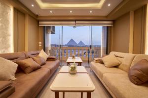 a living room with couches and a large window at Pyramids Charm Hotel in Cairo