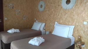 英雄港ALLuar Lodge的一间有两张床、铺着白色床单、配有镜子的房间 更多90张照片