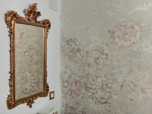 un espejo colgado en una pared junto a una pared con papel pintado en Apartamentos Casa Nino, en Montefrío