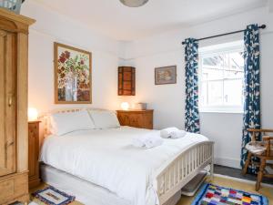een slaapkamer met een bed met handdoeken erop bij Naunton Cottage in Lyme Regis
