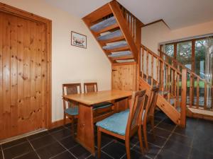 a dining room with a wooden table and stairs at The Granary in Bude