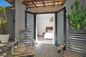 eine Terrasse mit 2 Stühlen und einem Kaktus in der Unterkunft Villa Santa Fé in Búzios