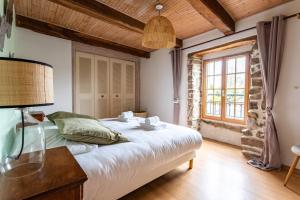 1 dormitorio con 1 cama con lámpara. en Kloz Ar Lore - piscine chauffée, en Plouër-sur-Rance