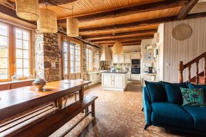 a large kitchen with a blue couch and a table at Kloz Ar Lore - piscine chauffée in Plouër-sur-Rance