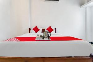 a bed with a red blanket and a blender on it at Flagship Cruze Residency in Coimbatore