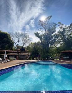 a large blue swimming pool with the sun in the sky at Hotel Santa Esmeralda in Bonito