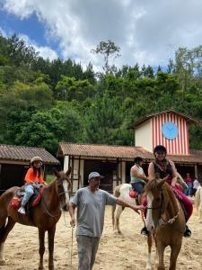 um grupo de pessoas montadas em cavalos com um homem em Fazenda Suica Le Canton em Teresópolis