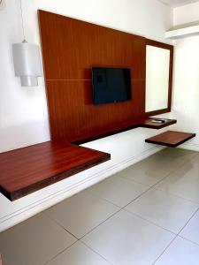 a living room with a flat screen tv on a wall at Hotel Village Porto de Galinhas - Apartamento 215 in Porto De Galinhas