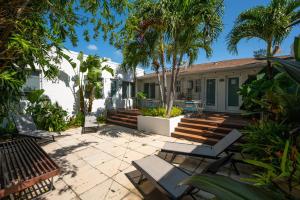 a patio with chairs and a house with palm trees at Casa Del Mar Master in Hollywood