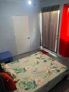 Cama en habitación con puerta y ventana en 1 habitation, en Boca Chica