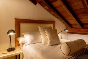 a bedroom with a white bed with two pillows at Palmas de Alba Hotel Boutique in Cartagena de Indias