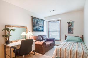a bedroom with a bed and a couch and a desk at Welcoming Condo in Davenport Central Location! in Davenport