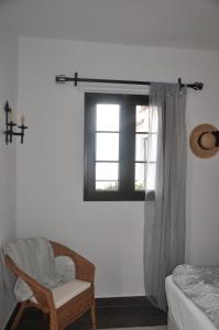 een slaapkamer met een stoel en een raam bij Nerja with view in Nerja