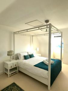 ein Schlafzimmer mit einem weißen Bett mit Himmelbett in der Unterkunft Large 5 Bedroom House with Parking for 2 Cars in Desborough