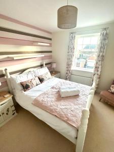 a bedroom with a large bed with a large window at 5 Bedroom Luxury House with Parking for 2 Cars in Desborough