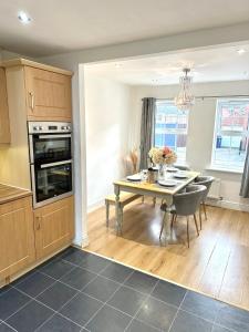 a kitchen and dining room with a table and chairs at 5 Bedroom Luxury House with Parking for 2 Cars in Desborough