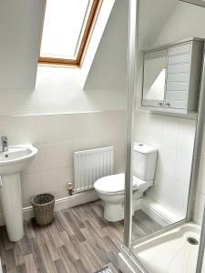 a bathroom with a toilet and a sink and a shower at 5 Bedroom Luxury House with Parking for 2 Cars in Desborough