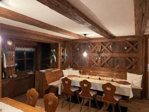 a dining room with a table and chairs and wooden walls at Pension 's Waldeck in Traunkirchen