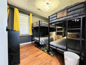1 Schlafzimmer mit 2 Etagenbetten und einem Fenster in der Unterkunft HI-TEK MANOR 2 - Prime Location - 2-75 inch 4K TVs in Charleston