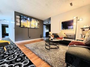 uma sala de estar com um sofá e uma mesa em HI-TEK MANOR 2 - Prime Location - 2-75 inch 4K TVs em Charleston