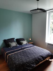 1 dormitorio con 1 cama con pared azul en Cosy Saint Yorre en Saint-Yorre