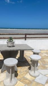 a picnic table with three seats and a potted plant at Casa na praia _Ceará in Acaraú