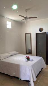 a bedroom with a white bed with flowers on it at Casa na praia _Ceará in Acaraú