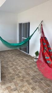a red hammock in a room with a tile floor at Casa na praia _Ceará in Acaraú